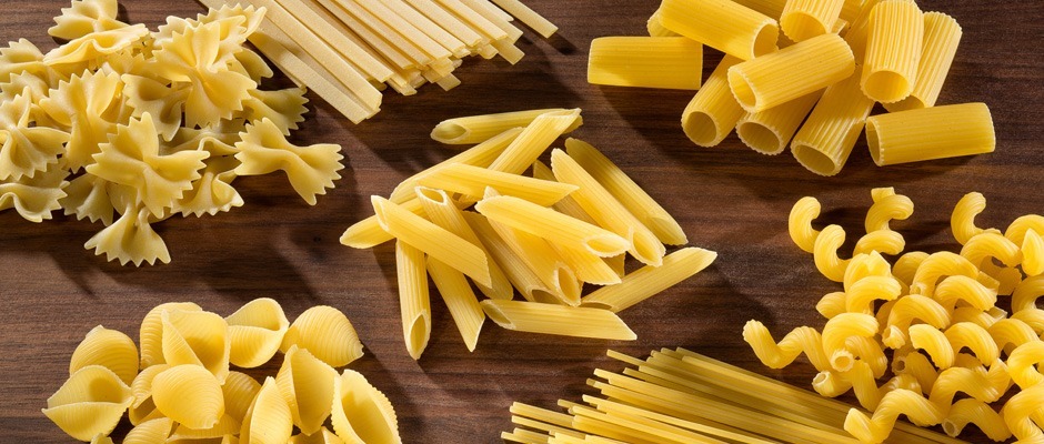Know Your Pasta Noodle Uncooked groups of pasta on cutting board with bowtie. fettuccini, shell, rigatoni, cavatappi and spaghetti pasta types